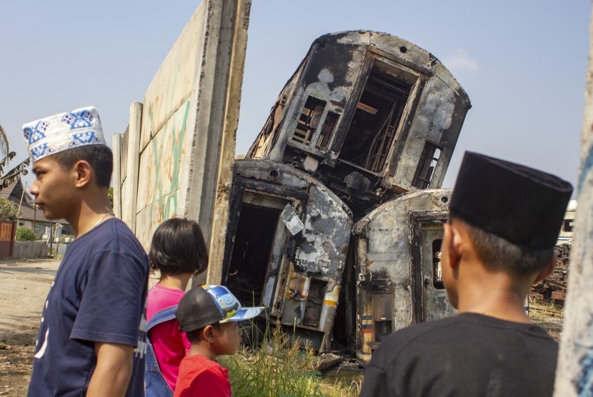 Warga melihat gerbong kereta bekas yang hangus terbakar di area penyimpanan di Stasiun Purwakarta, Purwakarta, Jawa Barat, Sabtu (6/7/2019). 