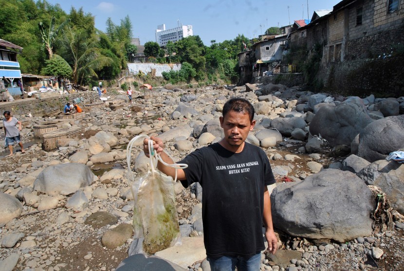 Penggiat lingkungan dari Komunitas Peduli Ciliwung menunjukkan limbah medis saat Mulung Sampah di sungai Ciliwung, Kampung Kebon Jukut, Kelurahan Babakan Pasar, Kota Bogor, Jawa Barat, Sabtu (6/7/2019).