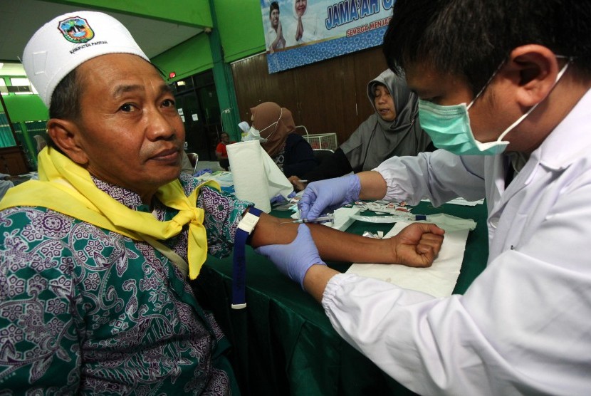 Petugas kesehatan mengambil darah calon haji untuk dites, di Asrama Haji Embarkasi Surabaya, di Surabaya, Jawa Timur, Sabtu (6/7/2019). 