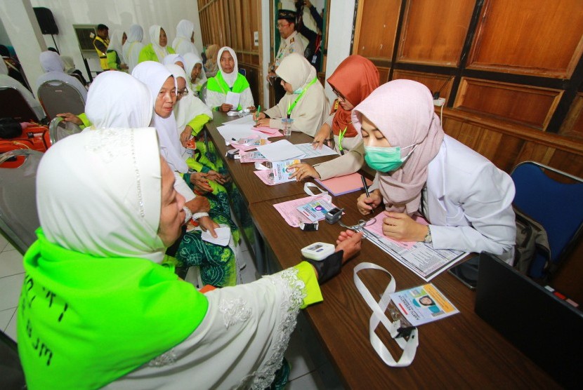 Petugas kesehatan memeriksa kesehatan jamaah calon haji (JCH) yang tergabung dalam kelompok terbang (kloter) I Embarkasi Banjarmasin sebelum memasuki Asrama haji Embarkasi Banjarmasin, Banjarbaru, Kalimantan Selatan, Senin (8/7/2019).