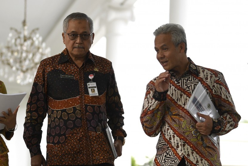 Gubernur Jawa Tengah Ganjar Pranowo (kanan) berbincang dengan Sekda Jawa Tengah Sri Puryono (kiri) usai mengikuti rapat terbatas tentang percepatan pembangunan di Istana Bogor, Jawa Barat, Selasa (9/7/2019).