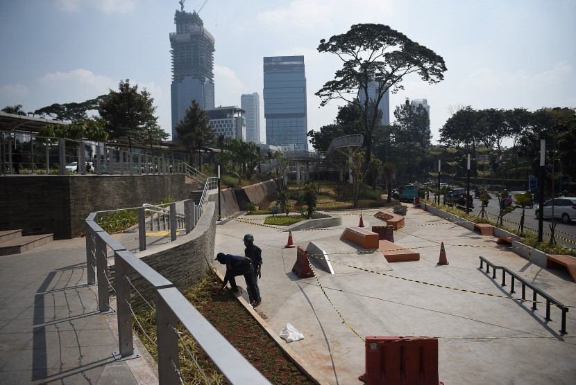 Sejumlah pekerja menyelesaikan proyek pembangunan Taman Spot dan Budaya, di Dukuh Atas, Jakarta, Jumat (12/7/2019).