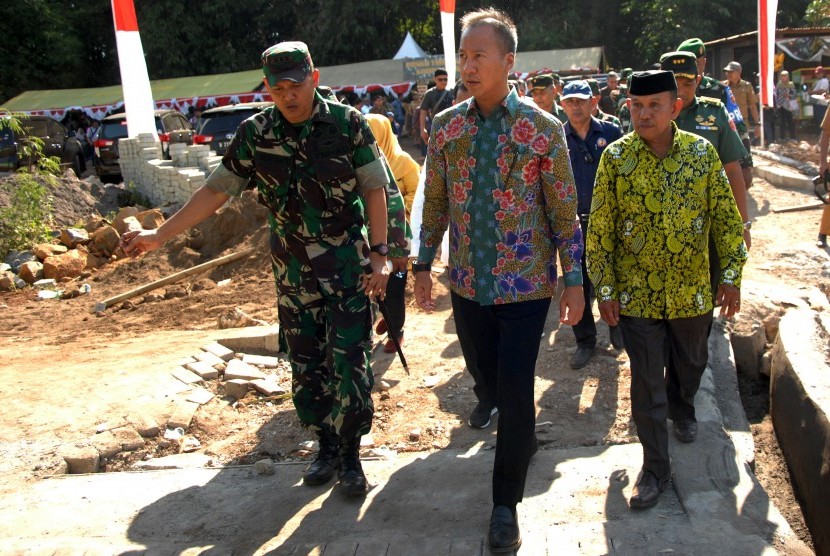 Menteri Sosial Agus Gumiwang Kartasasmita (tengah) didampingi Letkol Inf Andriyanto (kiri) meninjau pembangunan jalan dari program TNI Manunggal Membangun Desa (TMMD) usai penyerahan bantuan di Kecamatan Biringkanayya, Makassar, Sulawesi Selatan, Selasa (16/7/2019). 