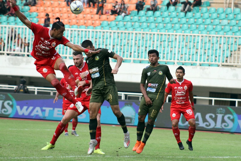 Pesepak bola Persija Jakarta Maman Abdurahman (kiri) berebut bula di udara dengan pesepak bola Tira Persikabo Khurshed Beknazarov (kedua kiri) dalam laga Liga 1 2019 di Stadion Pakansari, Bogor, Jawa Barat, Selasa (16/7/2019).