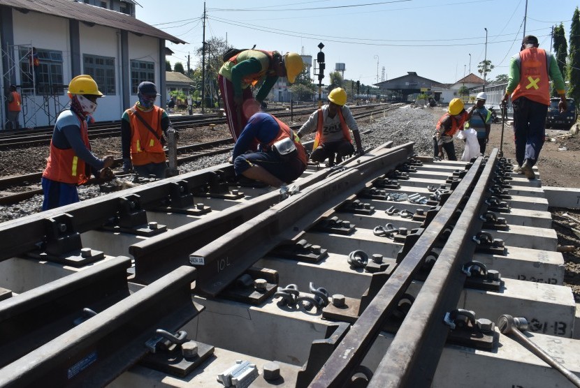Pekerja memasang rel dalam proyek jalur ganda kereta lintas selatan di kawasan Stasiun KA Madiun, Jawa Timur (ilustrasi).