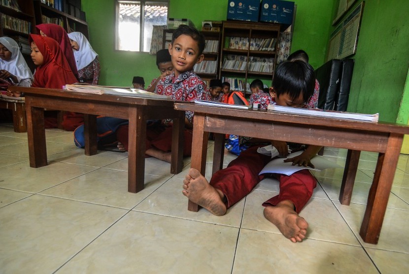 Siswa kelas dua Sekolah Dasar Negeri (SDN) Cikadongdong mengikuti Kegiatan Belajar Mengajar (KBM) di lantai ruang perpustakaan di Singaparna, Kabupaten Tasikmalaya, Jawa Barat, Rabu (17/7/2018).