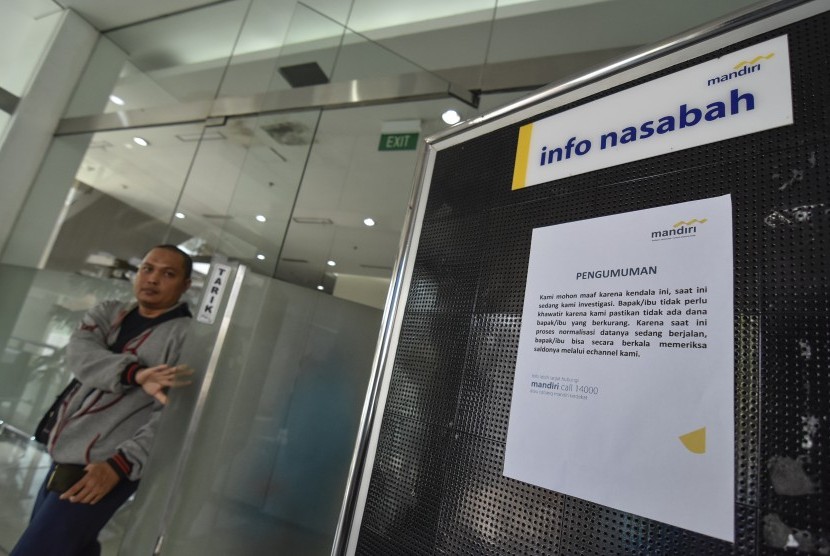 Seorang nasabah keluar dari kantor usai melakukan pengaduan berkurangnya saldo rekening mereka di kantor Bank Mandiri Mataram, NTB, Sabtu (20/7/2019).