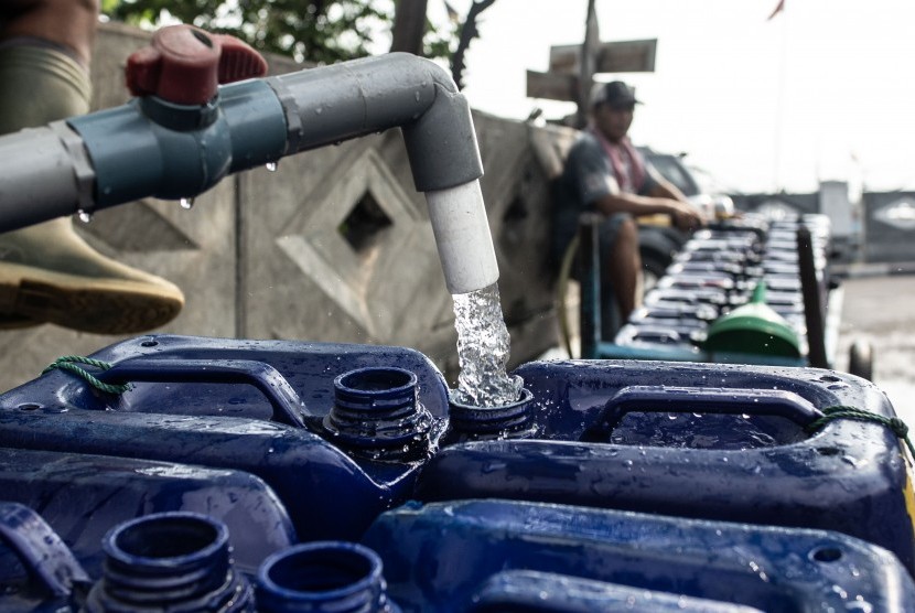 [Ilustrasi] Pekerja mengisi air bersih yang bersumber dari PAM Jaya ke jeriken.