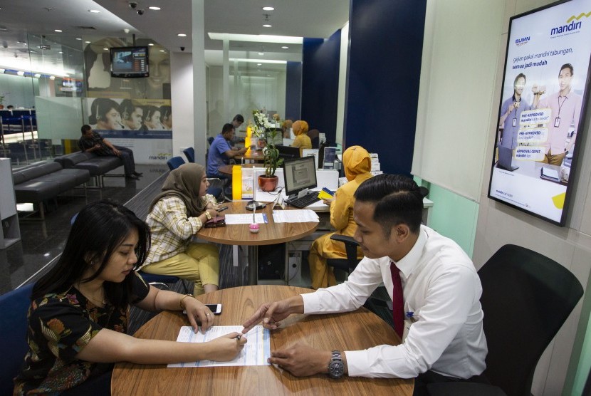 Pegawai melayani nasabah di Bank Mandiri, Jakarta, Senin (22/7/2019).