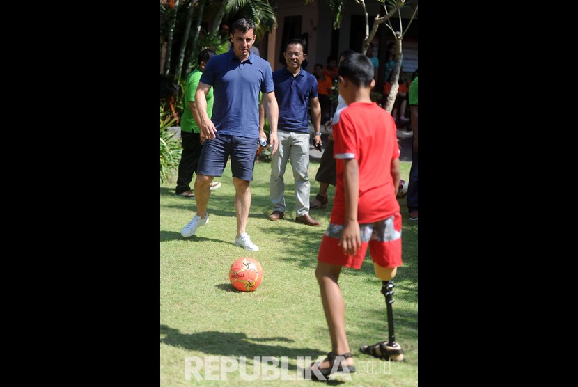 Mantan pesepak bola Manchester United Gary Neville (kiri) bermain sepak bola bersama penyandang disabilitas saat mengunjungi Annika Linden Centre di Denpasar, Bali, Senin (22/7/2019).