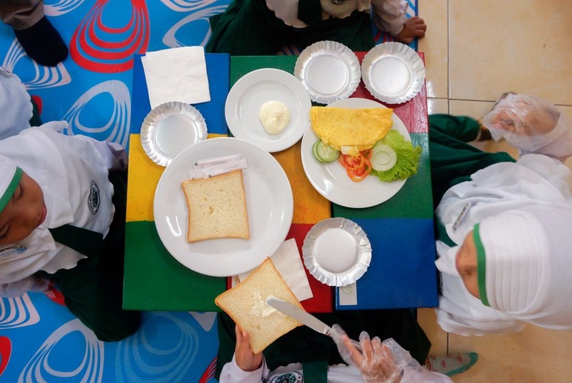 Anak mempraktikkan cara membuat makanan sarapan (Ilustrasi). Anak butuh makanan bergizi dan cukup tidur agar konsentrasinya meningkat di sekolah.