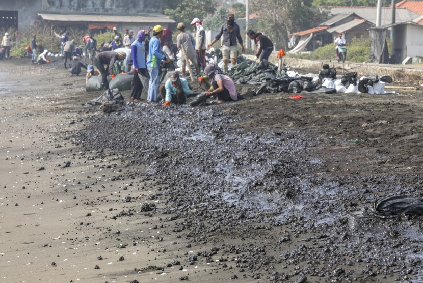Warga mengumpulkan limbah tumpahan minyak 'Oil Spill' yang tercecer milik Pertamina di Pesisir Pantai Cemarajaya, Karawang, Jawa Barat, Rabu (24/7/2019).