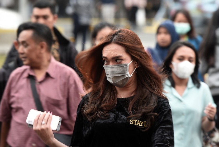 Sejumlah pejalan kaki menggunakan masker ketika melintas di kawasan Jalan Jenderal Sudirman, Jakarta, Kamis (25/7/2019).