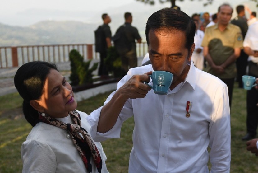 Presiden Joko Widodo (kanan) didampingi Ibu Negara Iriana Joko Widodo mencoba kopi lokal jenis Lintong Arabica saat mengunjungi kawasan Sipinsur Geosite di Kabupaten Humbang Hasundutan (Humbahas), Sumatera Utara, Senin (29/7/2019).