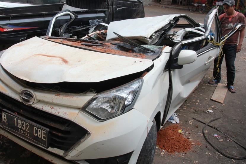 Warga melihat bangkai mobil kecelakaan maut yang hancur tertindih badan truk di Karawaci, Tangerang, Banten, Kamis (1/8/2019). 