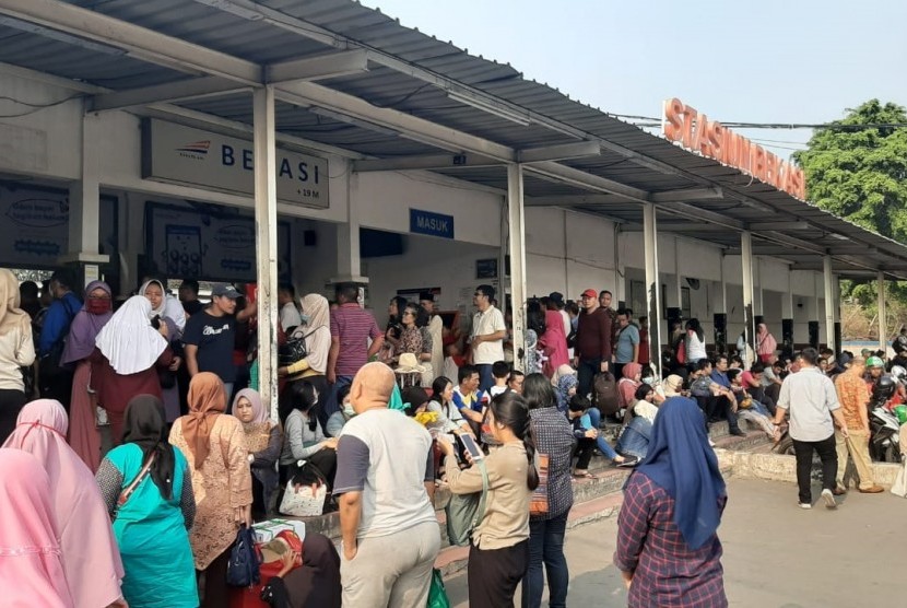 Ratusan calon penumpang memadati pintu masuk Stasiun Bekasi, Kota Bekasi, Ahad (4/8). Mereka menanti KRL kembali beroperasi.