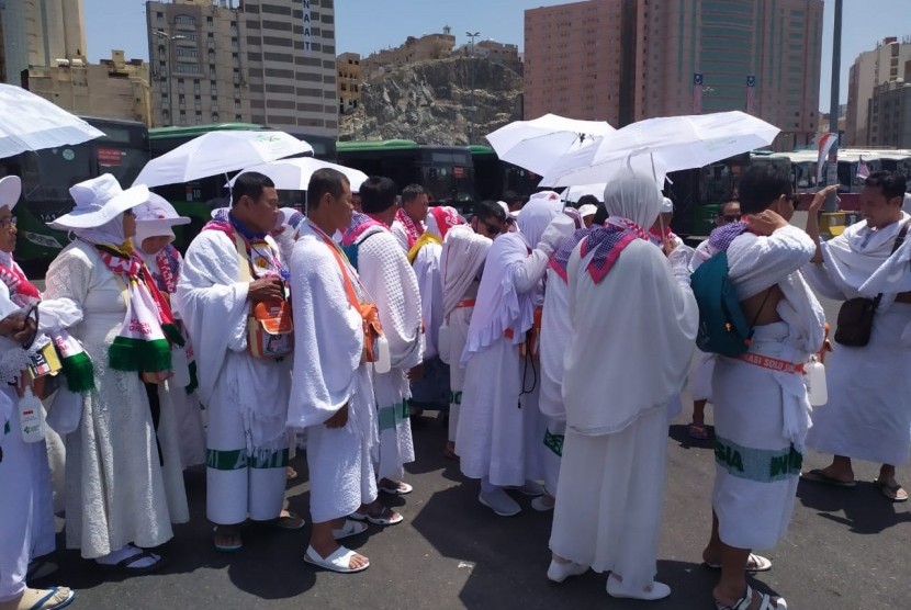 Jamaah haji menggunakan payung akibat cuaca yang sangat terik di Pos Terminak Syib Amir  Makkah, Senin (5/8).  Cuaca di Makkah pada siang hari mencapai 41 derajat Celsius dan malam 33 derajat Celsius 