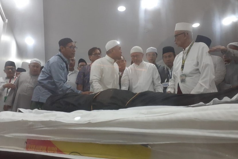 Menteri Agama sekaligus Amirul Hajj Lukman Hakim Saifuddin melihat jenazah KH Maimoen Zubair sebelum pelaksanaan shalat jenazah di Kantor Urusan Haji Indonesia, Makkah, Selasa (6/8). 