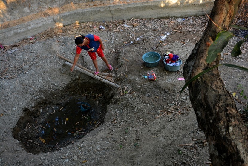 Warga mengambil air rembesan dari kubangan sungai yang mengering untuk kebutuhan mencuci dan mandi di Desa Marmoyo, Kecamatan Kabuh, Kabupaten Jombang, Jawa Timur, Selasa (6/8/2019).