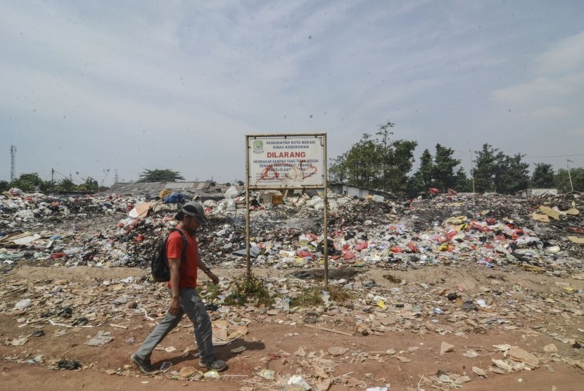 Pejalan kaki melintasi Tempat Pembuangan Sampah (TPS) ilegal di Bintara Jaya Bekasi, Jawa Barat,Rabu (7/8/2019). 