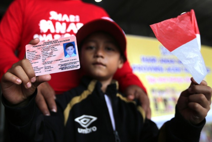 Seorang anak menunjukkan Kartu Identitas Anak (KIA) yang baru diterimanya di Banda Aceh, Aceh, Kamis (8/8/2019).