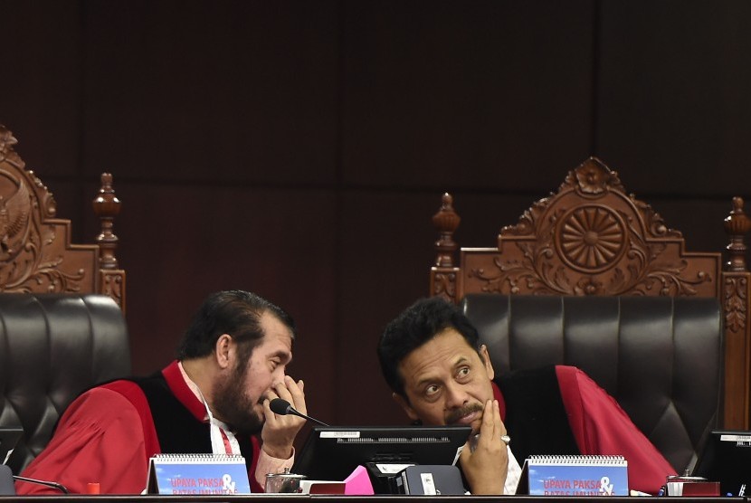 Ketua Mahkamah Konstitusi (MK) sekaligus pimpinan Majelis Hakim MK Anwar Usman (kiri) berdiskusi dengan Hakim MK I Dewa Gede Palguna di sela sidang putusan akhir untuk perkara sengketa hasil Pemilu Legislatif 2019 di Ruang Sidang Pleno Gedung MK, Jakarta, Jumat (9/8/2019). 