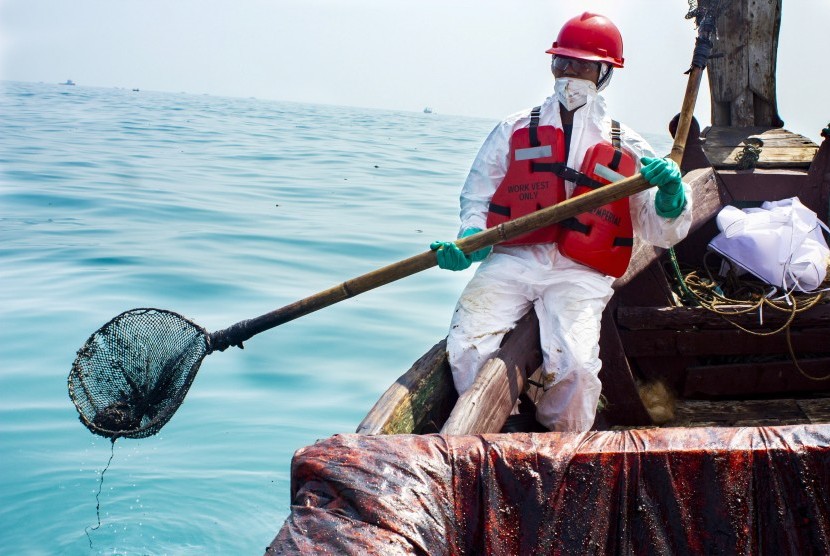 Petugas mengumpulkan tumpahan minyak mentah yang tercecer di Laut Utara Karawang, Jawa Barat, Senin (12/8/2019).