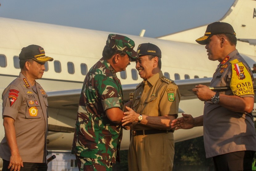 Panglima TNI Marsekal TNI Hadi Tjahjanto (kedua kiri) dan Kapolri Jenderal Tito Karnavian (kiri) disambut Gubernur Riau Syamsuar (kedua kanan) dan Kapolda Riau Irjen Pol Widodo Eko Prihastopo, saat tiba di Lanud Roesmin Nurjadin, di Pekanbaru, Riau, Senin (12/8/2019). 