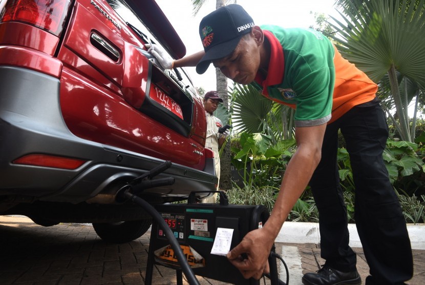 Seorang petugas Dinas Lingkungan Hidup Provinsi DKI Jakarta melakukan uji emisi kendaraan dinas saat peluncuran aplikasi e-Uji Emisi di Balai Kota DKI Jakarta, Selasa (13/8/2019). 