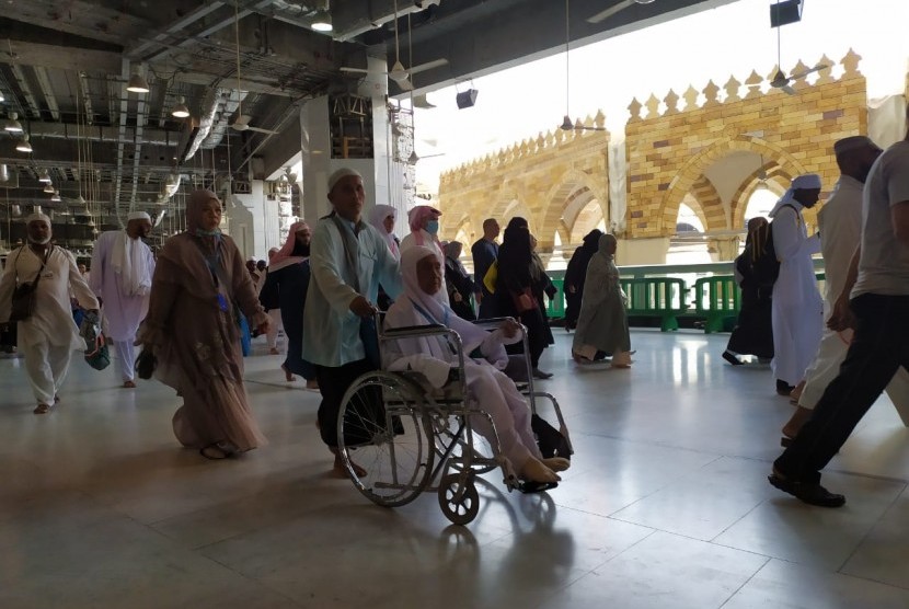 Seorang jamaah mendorong kursi roda yang digunakan istrinya untuk melaksanakan tawaf di lantai 2 Masjidil Haram, Rabu (14/8). Masjidil Haram kembali sesak dengan jamaah haji karena berakhirnya pelaksanaan jumrah di Mina yang mengambil nafar Tsani. 