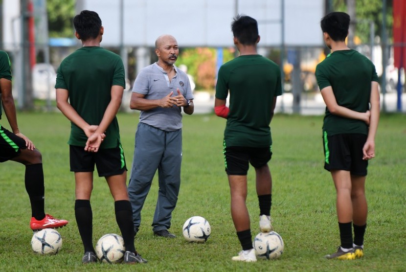 Pelatih Timnas U-18 Fakhri Husaini (tengah) memberikan arahan kepada pemainnya saat latihan di Lapangan Becamex Binh Duong, Vietnam, Kamis (15/8/2019). 