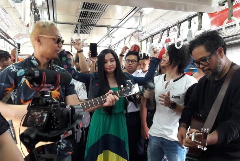 Band Cokelat tampil di salah satu gerbong KRL tujuan Bogor - Jakarta Kota, Kamis (15/8).