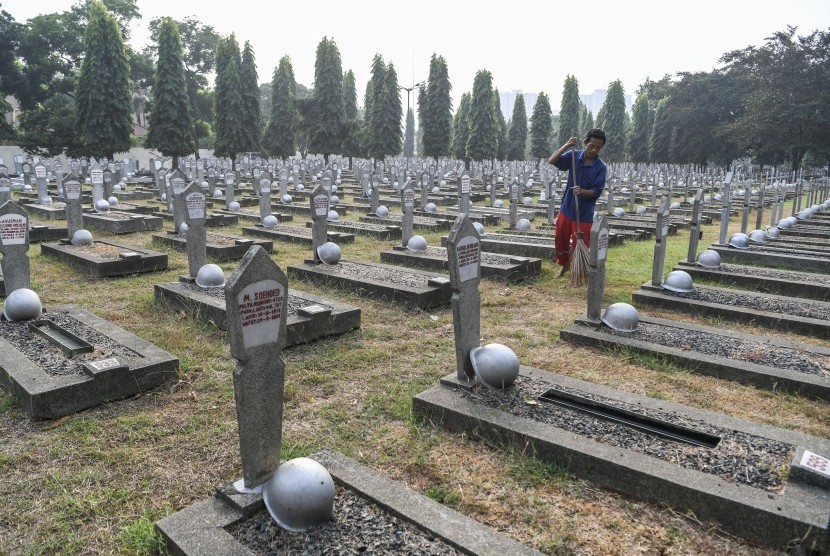 Petugas kebersihan menyapu area pemakaman di Taman Makam Pahlawan Kalibata, Jakarta. (ilustrasi)