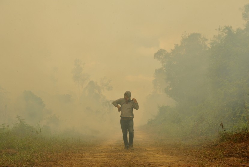 Warga berada di sekitar lahan gambut yang terbakar di Kumpeh Ulu, Muarojambi, Jambi, Kamis (15/8/2019).