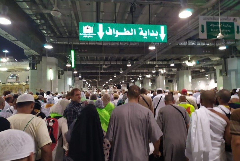 Pendaftaran Haji Iran Jalan Terus. Jamaah haji melambaikan tangan di sekitar tanda lampu hijau sebagai tanda dimulainya putaran tawaf.