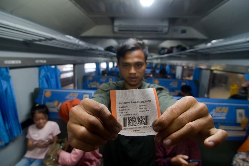 Penumpang menunjukkan tiket gratis di KA tujuan akhir Cicalengka di Stasiun Bandung, Jawa Barat. PT KAI menyiapkan sejumlah voucher tiket gratis KA jarak jauh untuk para guru dan nakes dalam menyambut Hari Pahlawan.