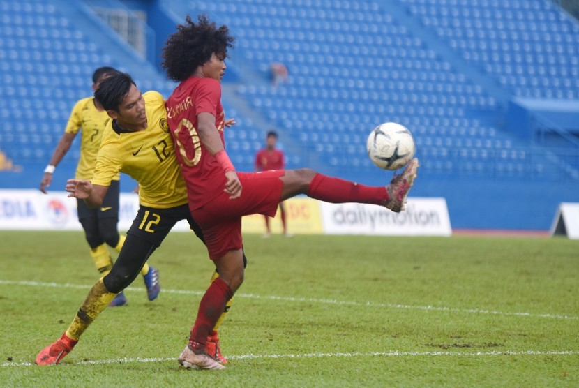 Pesepak bola Indonesia Bagus Kahfi (kanan) berebut bola dengan pesepak bola Malaysia Muhammad Aidil Azuan (kiri) saat bertanding pada semifinal Piala AFF U-18 di Stadion Go Dau di Provinsi Binh Duong, Vietnam, Sabtu (17/8/2019).