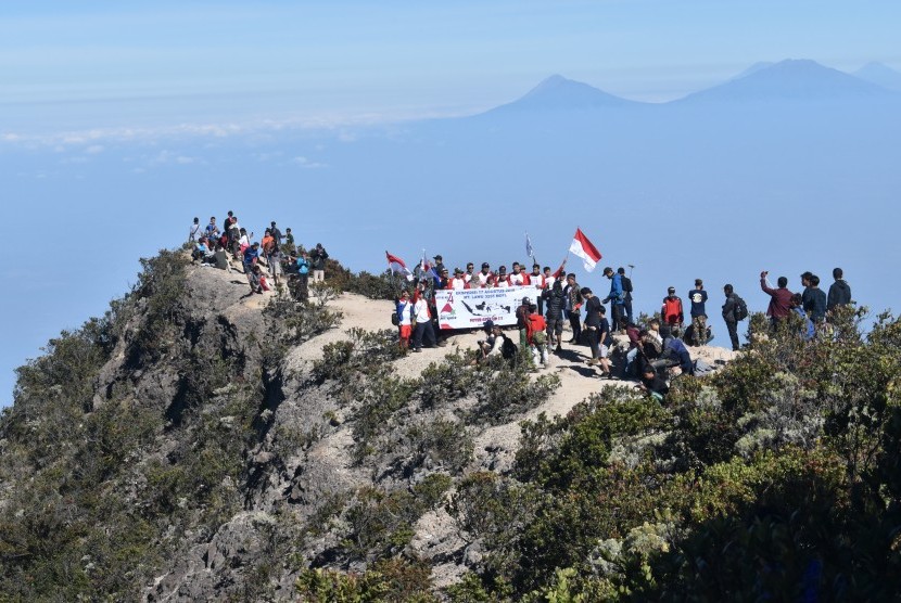 Pendaki mengibarkan bendera Merah Putih sambil menyanyikan lagu kebangsaan Indonesia Raya saat memperingati Hari Ulang Tahun ke-74 Proklamasi Kemerdekaan RI di kawasan Puncak Gunung Lawu Magetan, Jawa Timur. Ilustrasi