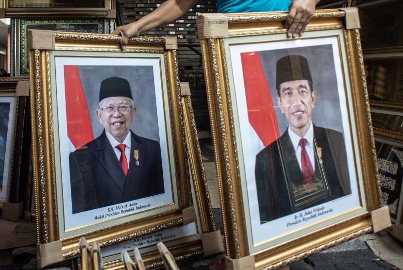 Pedagang merapikan poster Presiden Joko Widodo dan Wakil Presiden terpilih Ma'ruf Amin yang dijualnya di kawasan Sawah Besar, Jakarta, Rabu (21/8/2019).