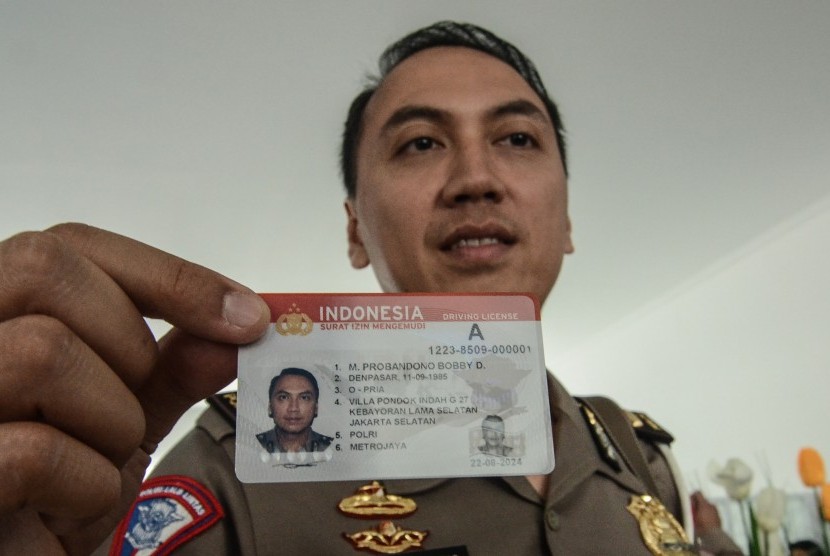 Polisi menunjukkan kartu Smart SIM (Surat Izin Mengemudi) di Gedung Satuan Penyelenggara Administrasi (Satpas) dan gerai SIM di Kabupaten Bekasi, Cikarang, Jawa Barat, Kamis (22/8/2019). 