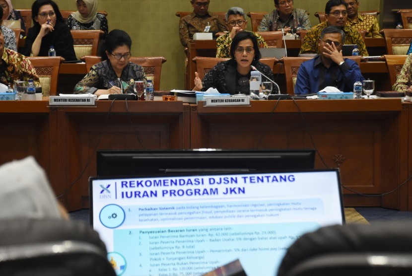 Menteri Keuangan Sri Mulyani Indrawati (tengah) dan Menteri Kesehatan Nila F. Moeloek (kiri) menyampaikan paparannya saat mengikuti rapat kerja gabungan dengan dengan Komisi IX dan Komisi XI DPR di Kompleks Parlemen Senayan, Jakarta, Selasa (27/8/2019). 