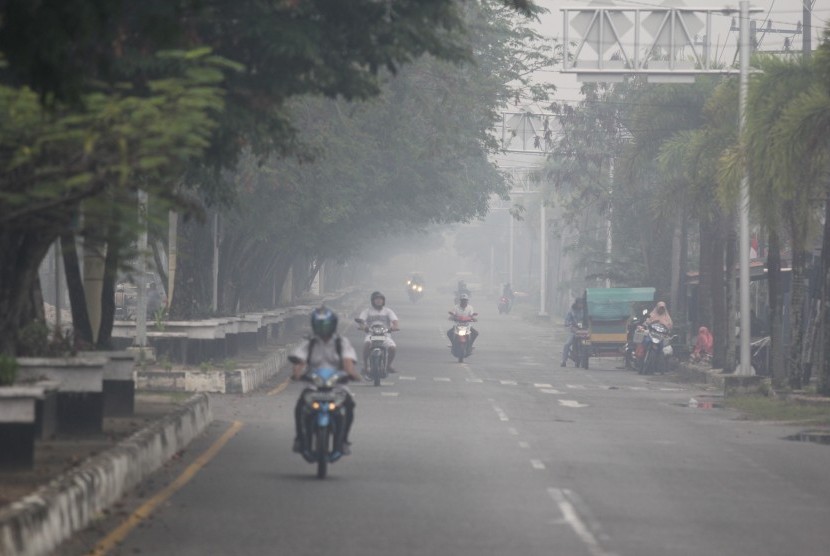 Jalan diselimuti asap dari kebakaran hutan di Kota Dumai, Dumai, Riau.