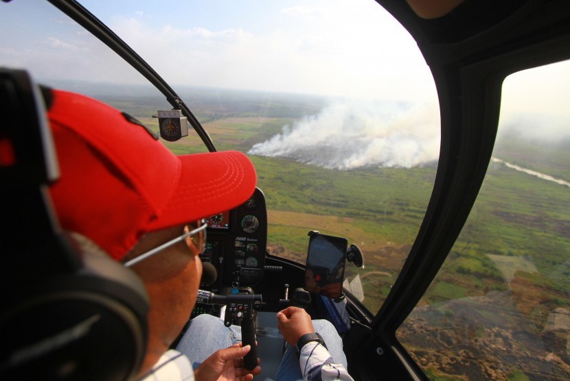 Petugas Badan Nasional Penanggulangan Bencana (BNPB) melakukan patroli udara kebakaran hutan dan lahan (karhutla) di sejumlah kabupaten di Kalimantan Selatan, Kamis (29/8/2019).