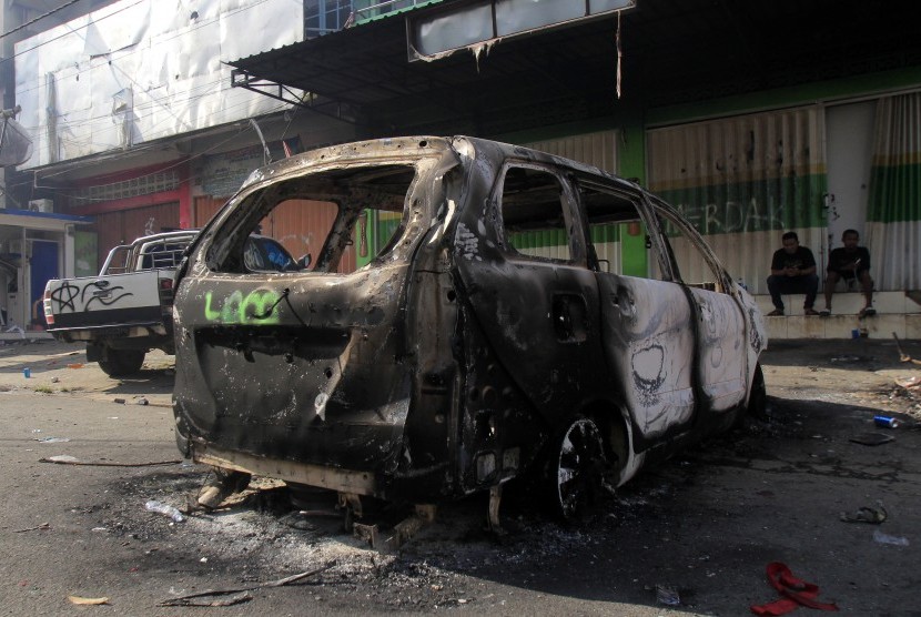 Bangkai mobil yang terbakar masih tergeletak di pinggir jalan, di Jayapura, Papua, Jumat (30/8/2019). 