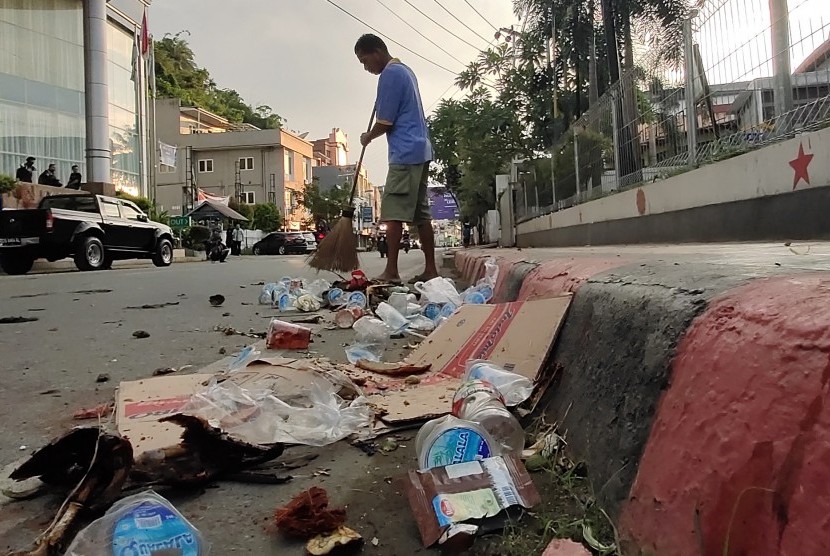 Seorang warga membersihkan sampah seusai berlangsungnya aksi unjuk rasa di Jayapura, Papua, Jumat (30/8/2019).