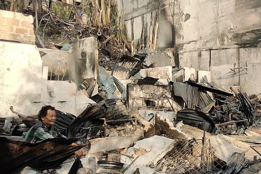 Seorang warga berada di puing bangunan yang terbakar di Jayapura, Papua, Jumat (30/8/2019). 