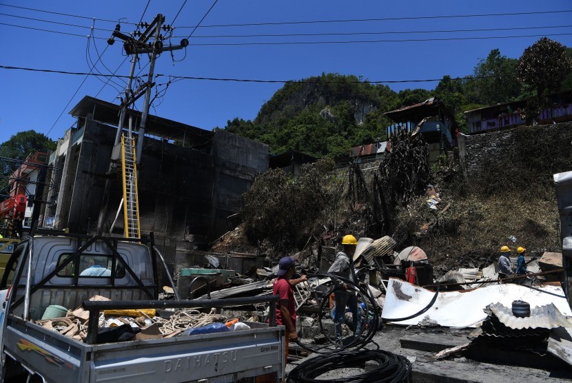 Petugas menata sambungan listrik yang rusak di salah satu rumah warga yang terbakar di Jayapura, Papua, Sabtu (31/8/2019).