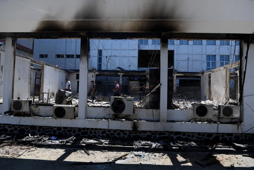 Karyawan memeriksa kondisi bangunan Kantor KPU Papua yang hangus terbakar di Jayapura, Papua, Sabtu (31/8/2019).