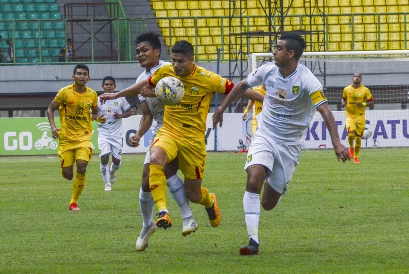 Pesepak bola Bhayangkara Fc Ramiro (tengah) dijaga pemain belakang Persebaya Dutra (kanan) pada lanjutan liga 1 di Stadion Patriot Chandrabahaga, Bekasi, Jawa Barat, Sabtu (31/8/2019).
