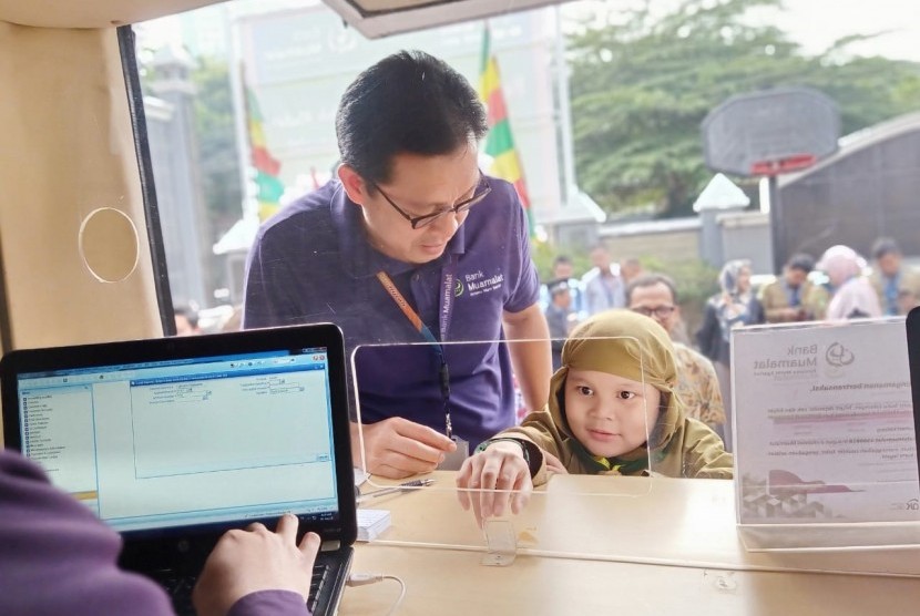 Chief Executive Officer PT Bank Muamalat Indonesia Tbk. Achmad K. Permana melayani langsung transaksi perbankan siswa Sekolah Muhammadiyah di Jalan Limau, Jakarta Selatan pada Rabu, (4/9).